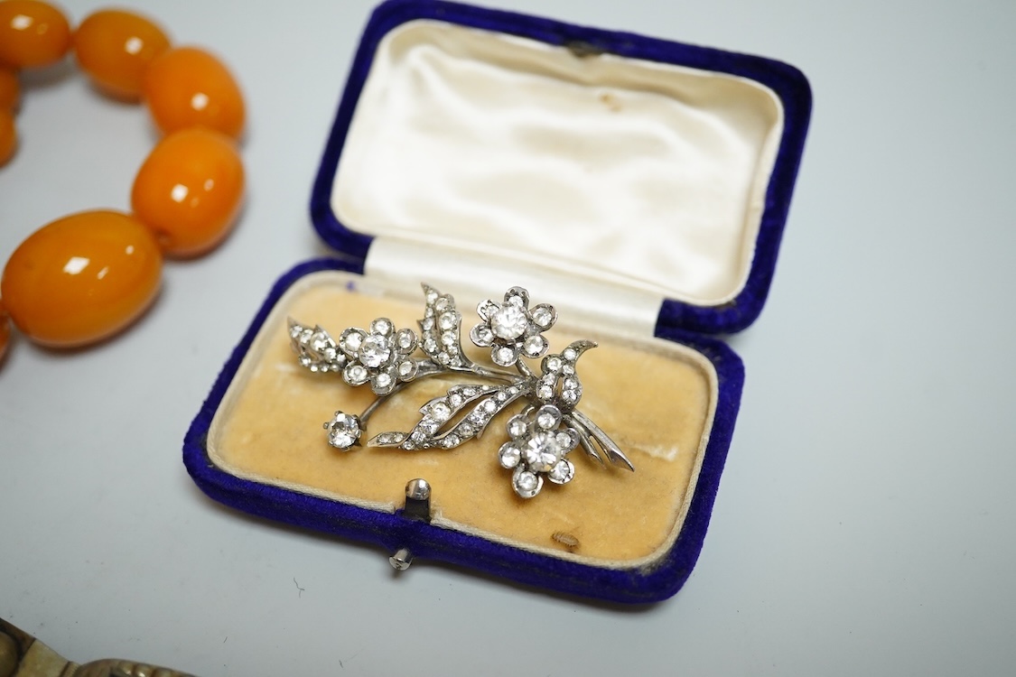 A group of antique and later jewellery inc. cased paste set spray brooch, a Mexican paste set brooch, a paste set shoe buckle and a pressed amber necklace.
